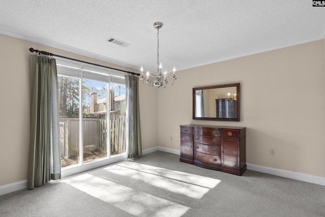 unfurnished dining area with a notable chandelier, ornamental molding, carpet, and a textured ceiling