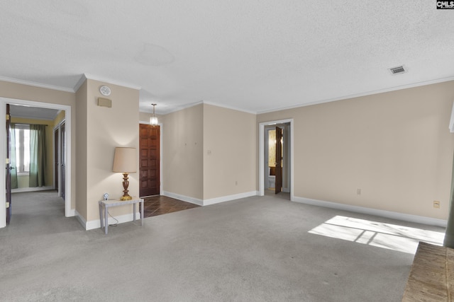 empty room with ornamental molding, carpet, and a textured ceiling