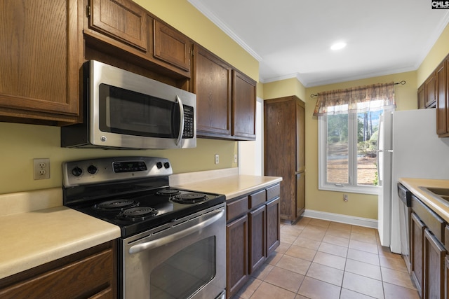 kitchen featuring crown molding, stainless steel appliances, and light tile patterned flooring