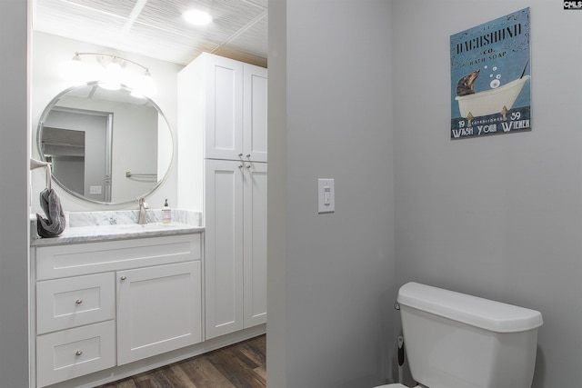 bathroom with vanity, toilet, and wood-type flooring