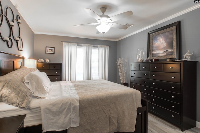 bedroom with crown molding, light hardwood / wood-style flooring, and ceiling fan