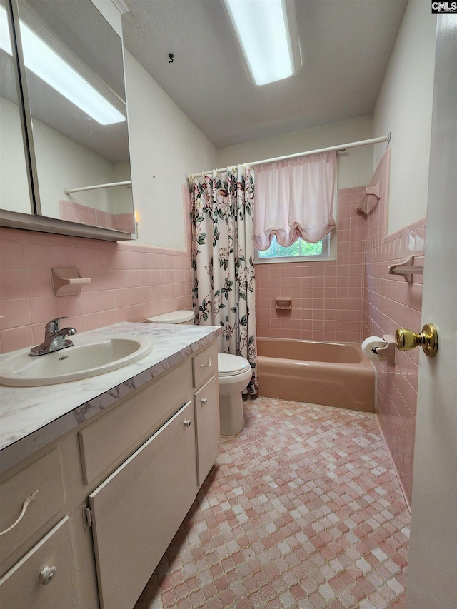 full bathroom with vanity, toilet, tile walls, and shower / bath combo