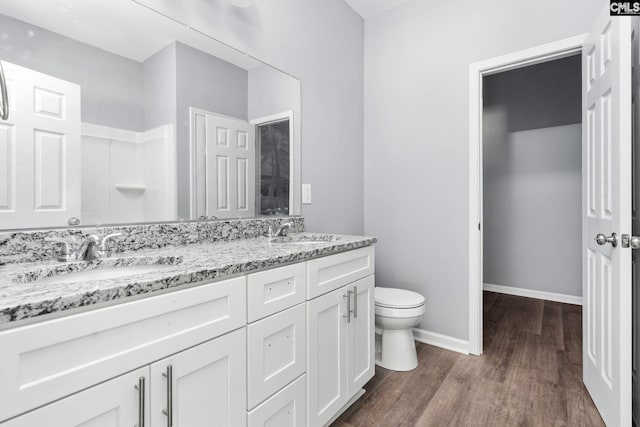 bathroom featuring vanity, hardwood / wood-style floors, walk in shower, and toilet