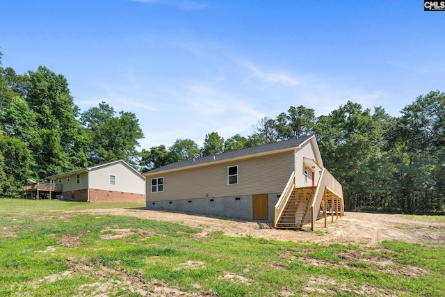 back of property featuring a lawn and a deck