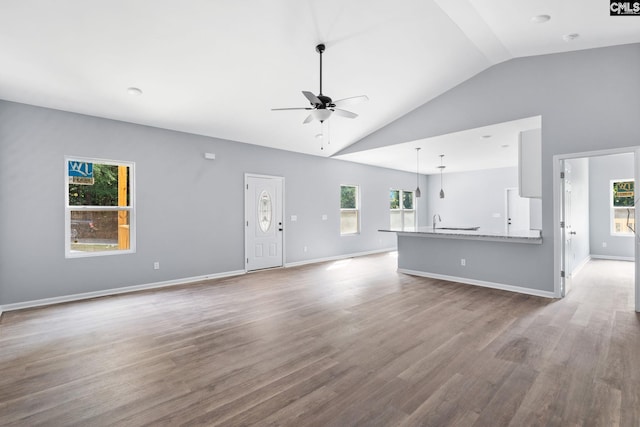 unfurnished living room with high vaulted ceiling, ceiling fan, and light wood-type flooring