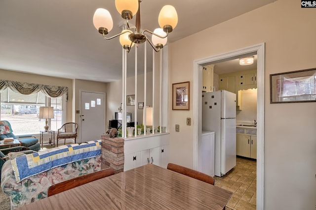 dining area with sink and a notable chandelier