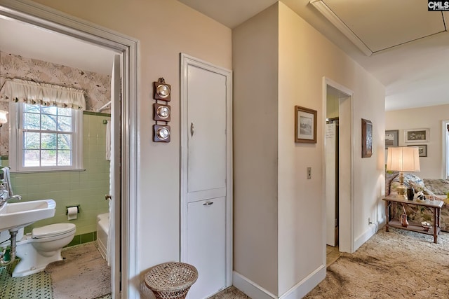 bathroom featuring tile walls, sink, and toilet