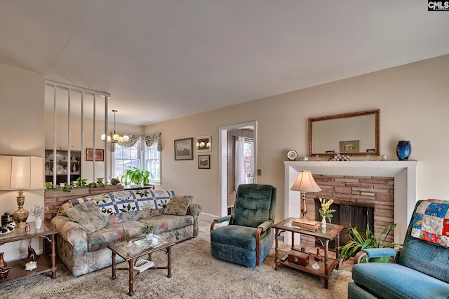 living room with carpet flooring, a stone fireplace, and a notable chandelier