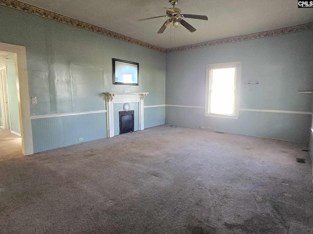 unfurnished living room featuring ceiling fan and carpet floors