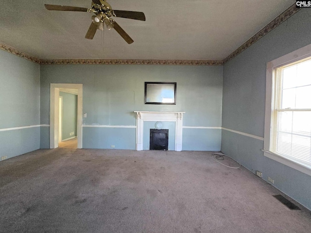 unfurnished living room featuring ornamental molding, carpet floors, and ceiling fan