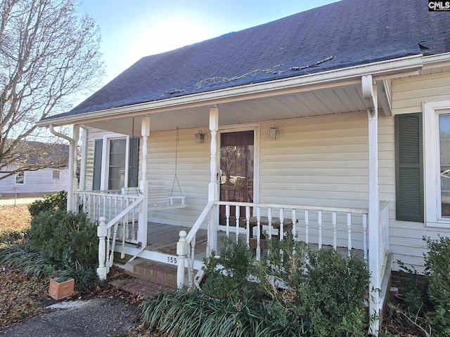 view of exterior entry featuring covered porch