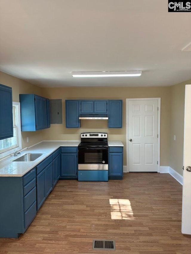 kitchen featuring light wood-type flooring, blue cabinets, sink, and electric range