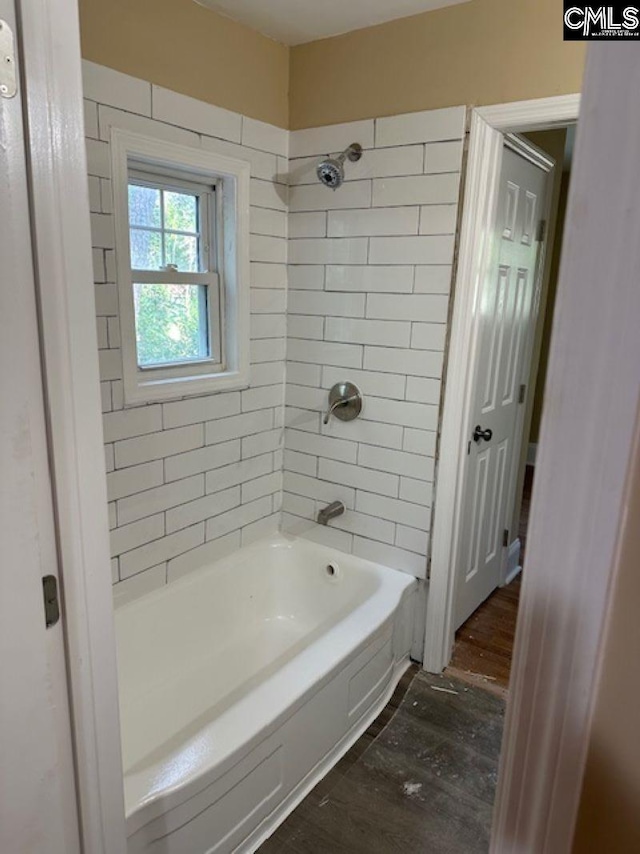 bathroom with hardwood / wood-style floors and tiled shower / bath combo