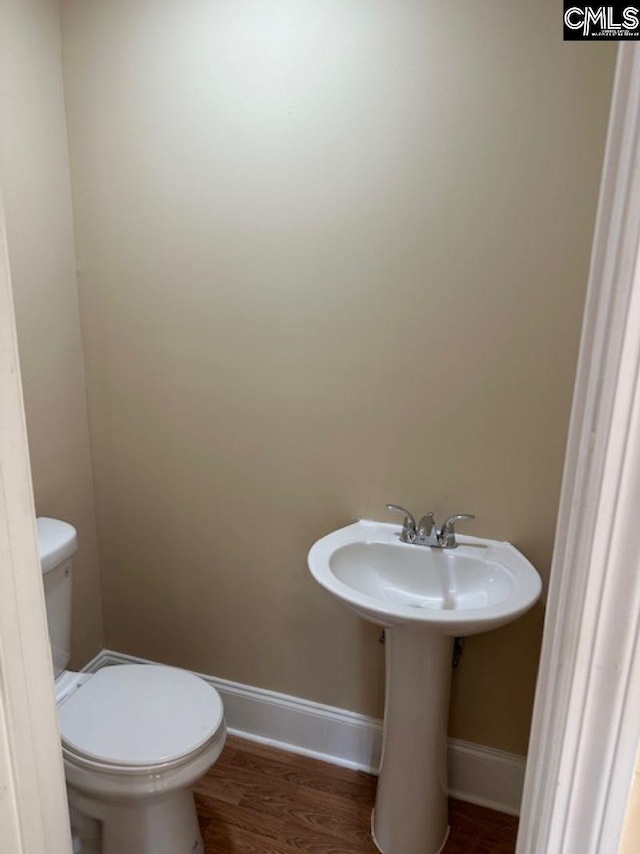 bathroom with toilet and hardwood / wood-style floors