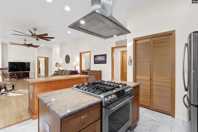 kitchen with a kitchen island, island exhaust hood, ceiling fan, stainless steel appliances, and light stone countertops