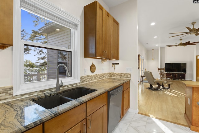 kitchen with sink, ceiling fan, tasteful backsplash, stone countertops, and stainless steel dishwasher