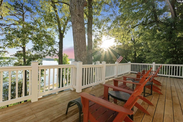 deck at dusk featuring a water view