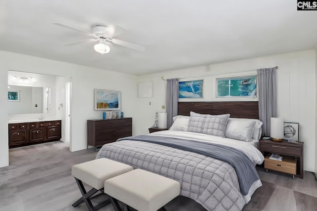 bedroom featuring connected bathroom, ceiling fan, and light wood-type flooring