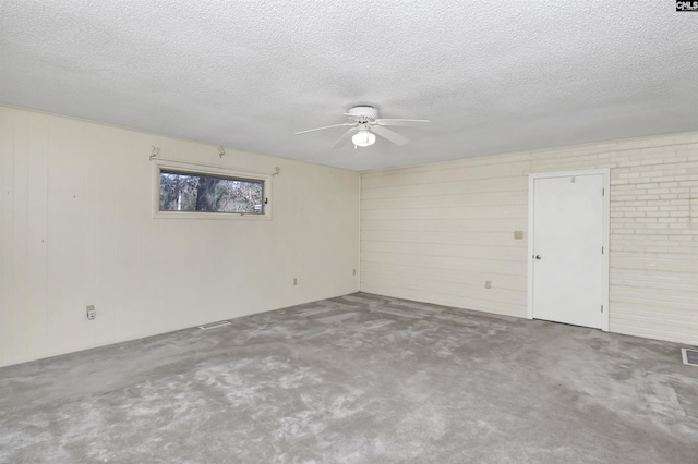 unfurnished room with ceiling fan, concrete floors, and a textured ceiling