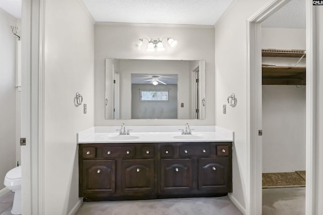 bathroom featuring vanity, ceiling fan, toilet, and a textured ceiling