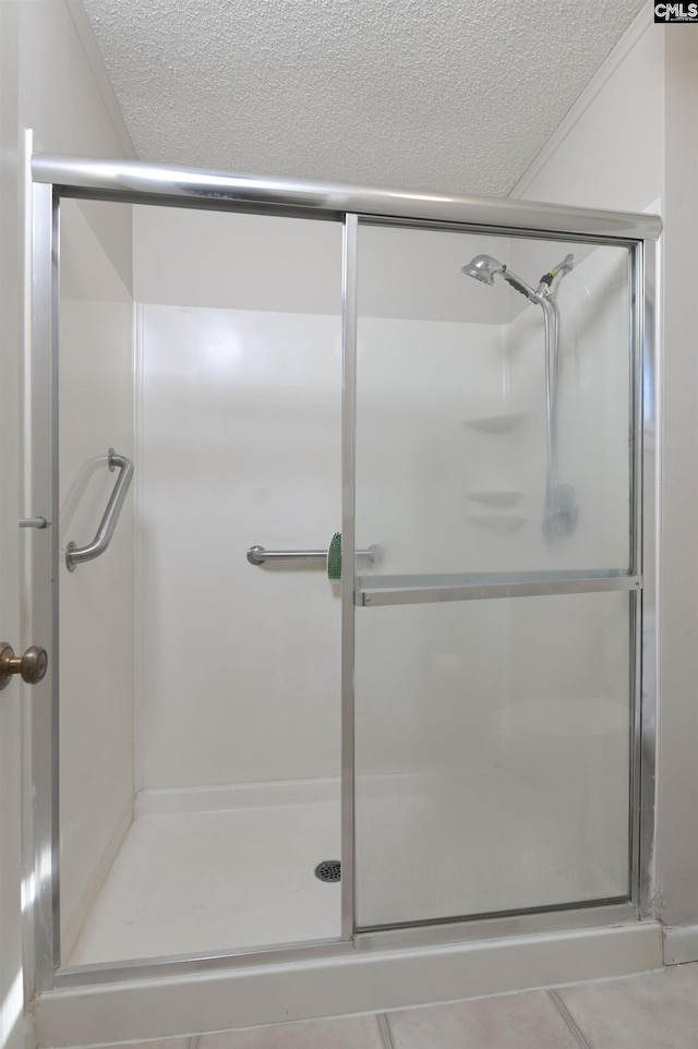 bathroom with a shower with door and a textured ceiling