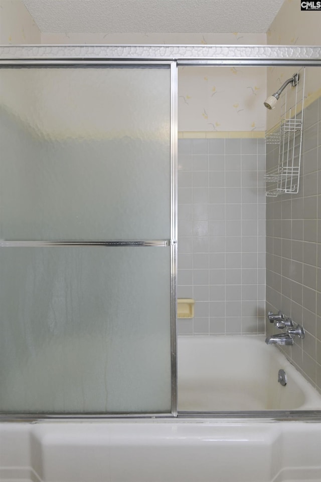 bathroom with enclosed tub / shower combo and a textured ceiling