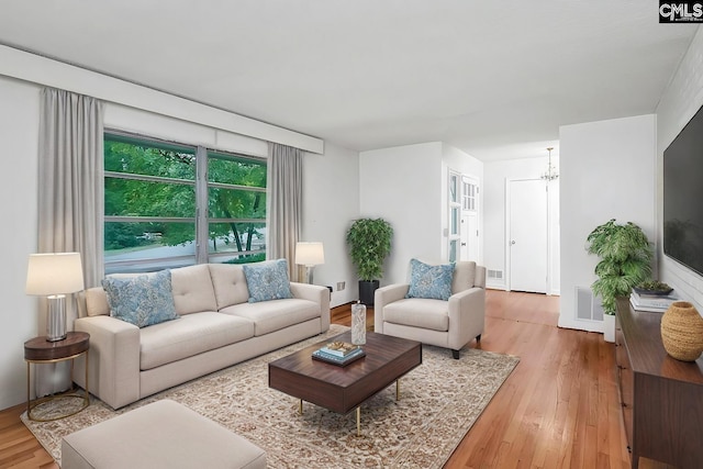 living room with an inviting chandelier and hardwood / wood-style floors