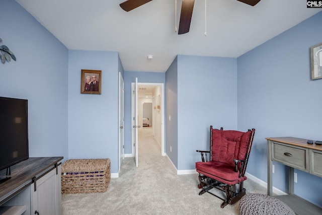 sitting room featuring light carpet and ceiling fan