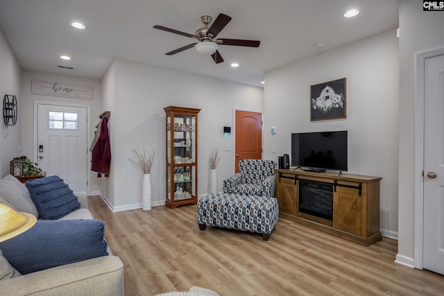 living room featuring ceiling fan and light hardwood / wood-style floors