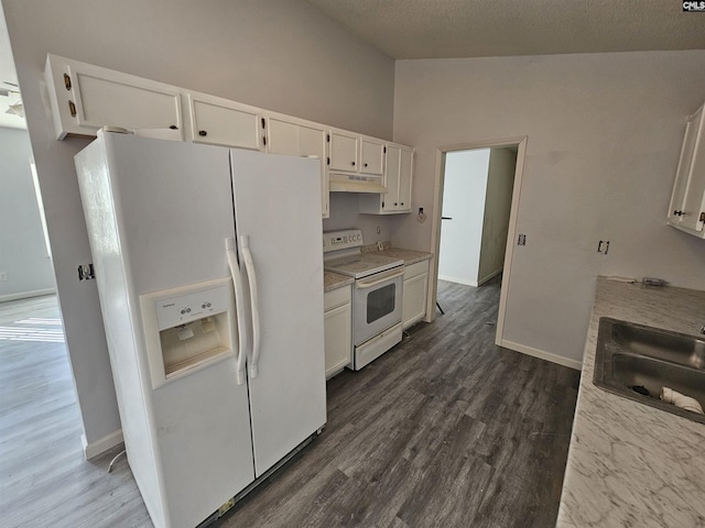 kitchen featuring vaulted ceiling, sink, white cabinets, and white appliances