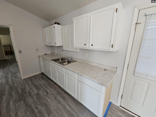 kitchen featuring dark wood-type flooring, sink, white cabinetry, a textured ceiling, and white dishwasher