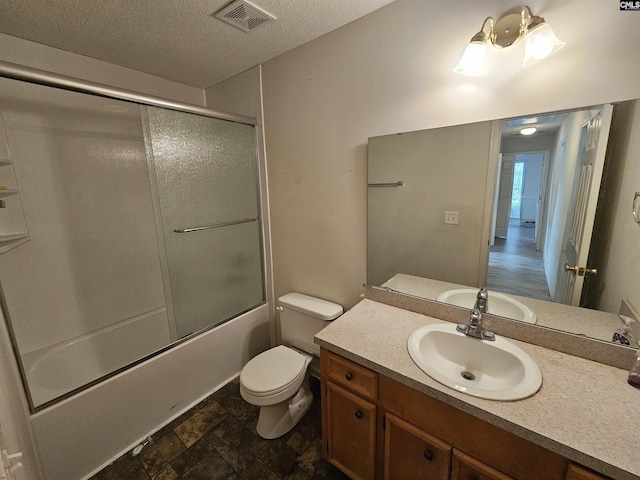 full bathroom featuring bath / shower combo with glass door, vanity, a textured ceiling, and toilet