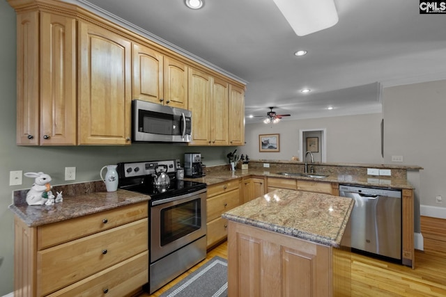 kitchen featuring sink, light brown cabinets, appliances with stainless steel finishes, kitchen peninsula, and light stone countertops