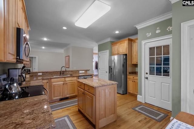 kitchen with a kitchen island, sink, stainless steel appliances, light stone countertops, and light hardwood / wood-style flooring