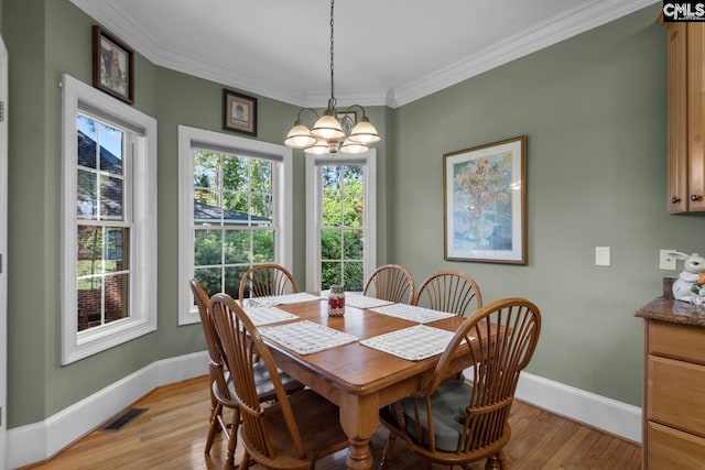 dining area featuring crown molding, light hardwood / wood-style floors, and a chandelier