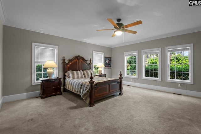 bedroom featuring multiple windows, ornamental molding, and light carpet