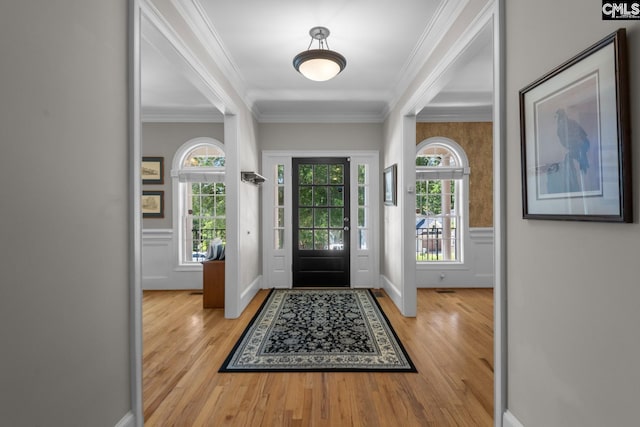 entrance foyer with crown molding and light hardwood / wood-style floors