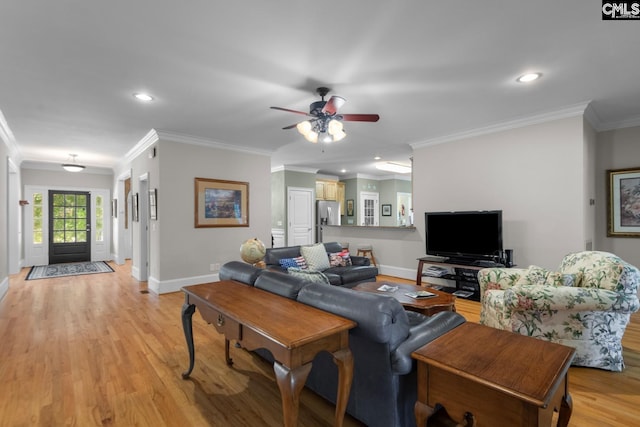 living room with crown molding, ceiling fan, and light hardwood / wood-style floors