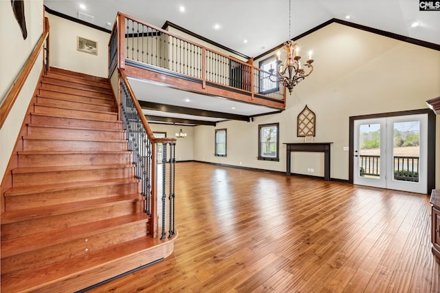 interior space with a healthy amount of sunlight, hardwood / wood-style floors, a high ceiling, and a notable chandelier