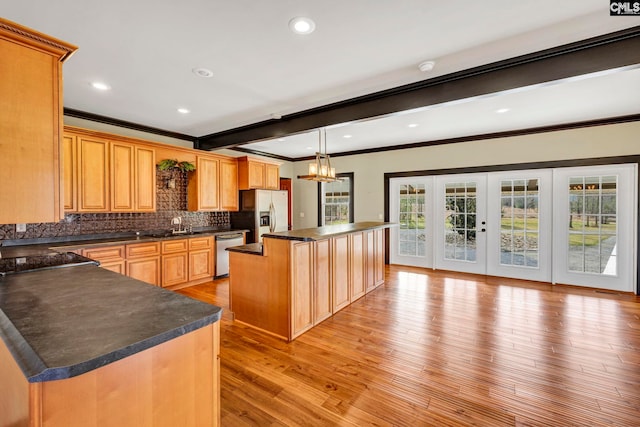 kitchen featuring tasteful backsplash, decorative light fixtures, a center island, appliances with stainless steel finishes, and beamed ceiling