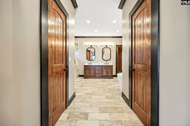 bathroom with crown molding, vanity, and a bathing tub