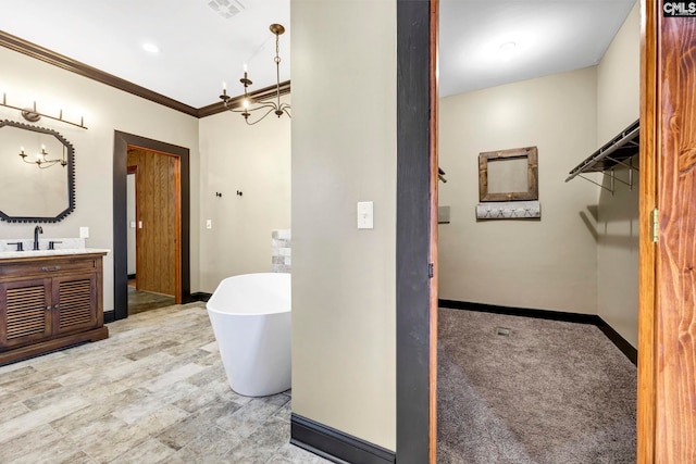 bathroom with vanity, a notable chandelier, a bathtub, and ornamental molding