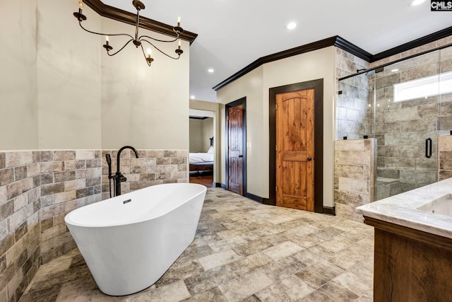 bathroom with tile walls, vanity, crown molding, and separate shower and tub