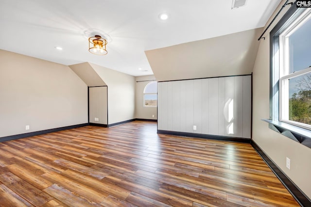 additional living space with hardwood / wood-style flooring