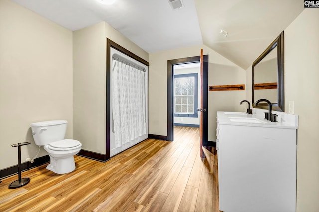 bathroom with lofted ceiling, vanity, toilet, and hardwood / wood-style floors