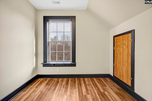 bonus room featuring a healthy amount of sunlight, vaulted ceiling, and light wood-type flooring