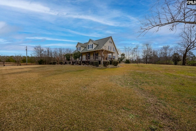 view of side of home with a yard and covered porch