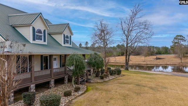 view of property exterior with a deck with water view and a lawn