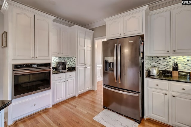 kitchen featuring stainless steel appliances, white cabinetry, and light hardwood / wood-style floors