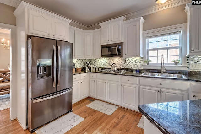 kitchen featuring sink, tasteful backsplash, light hardwood / wood-style flooring, stainless steel appliances, and white cabinets